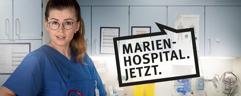 Fünf Pflegekräfte in Arbeitskleidung lächeln